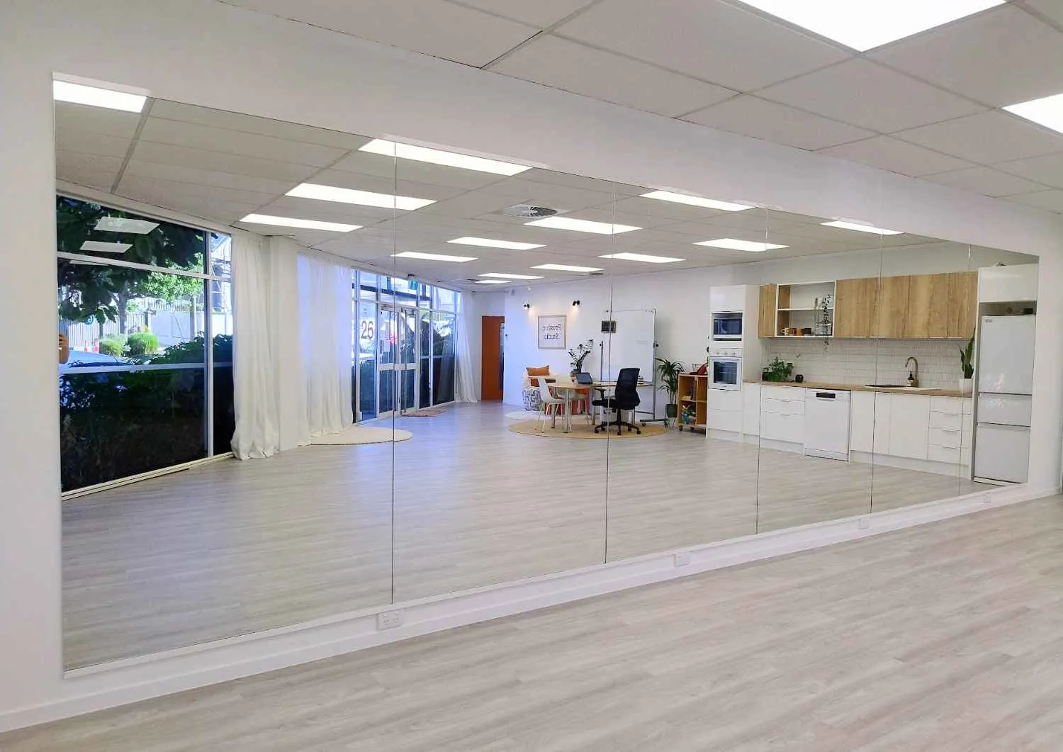 The main room at Prosford Studio: a wooden floor, a wall of mirrors and tall windows.